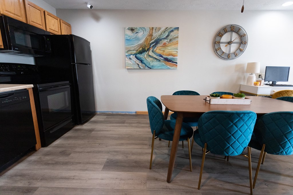 a kitchen and dining room with a table and chairs and a clock on the wall