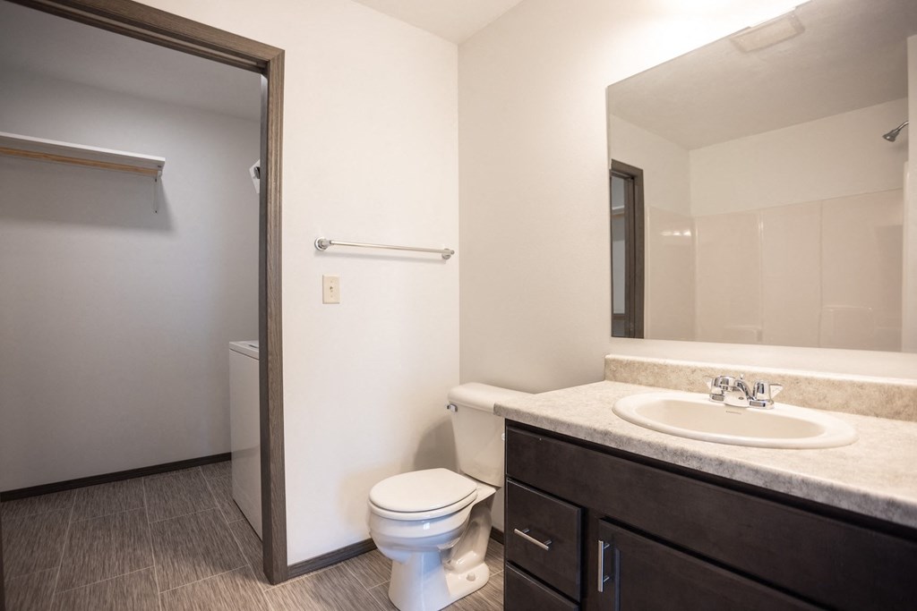 a bathroom with a toilet sink and mirror and a shower
