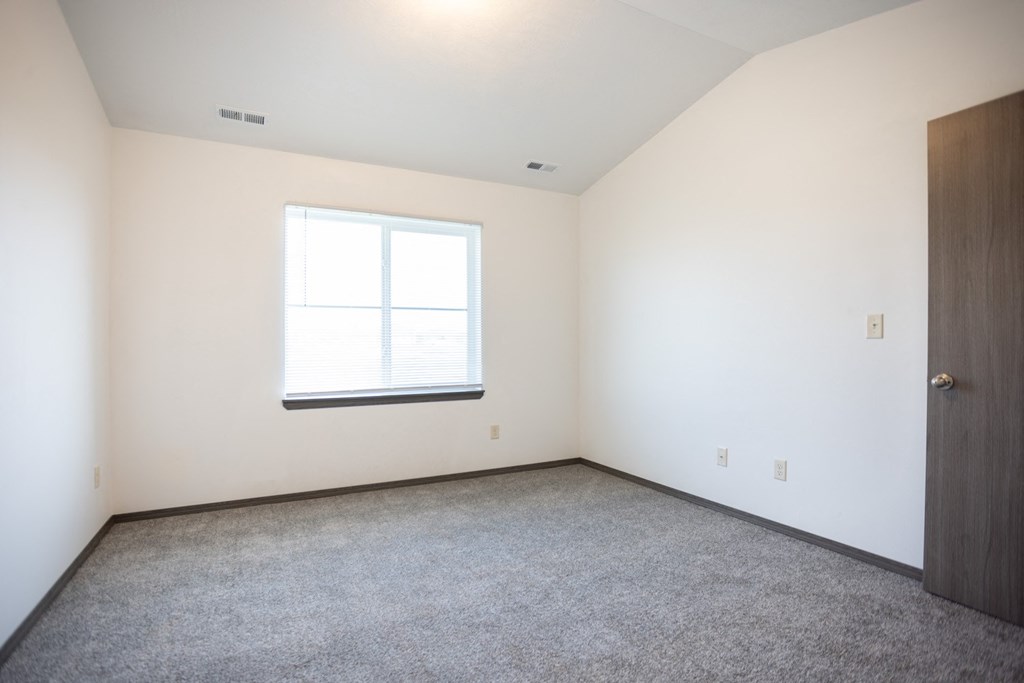 an empty room with a window and a door
