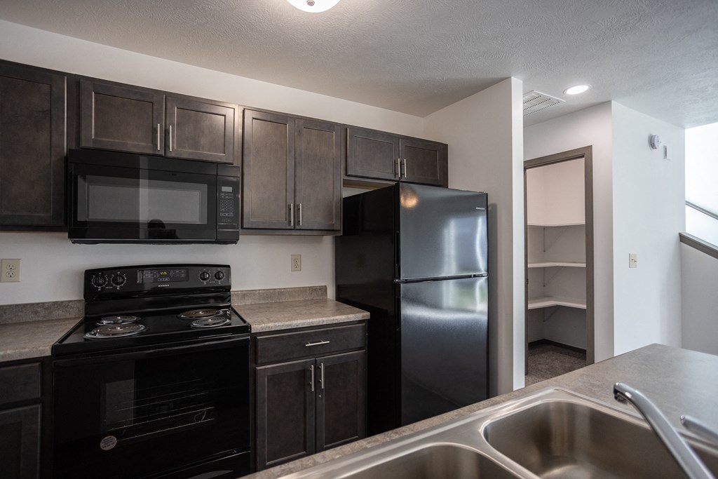 an empty kitchen with black appliances and a black refrigerator