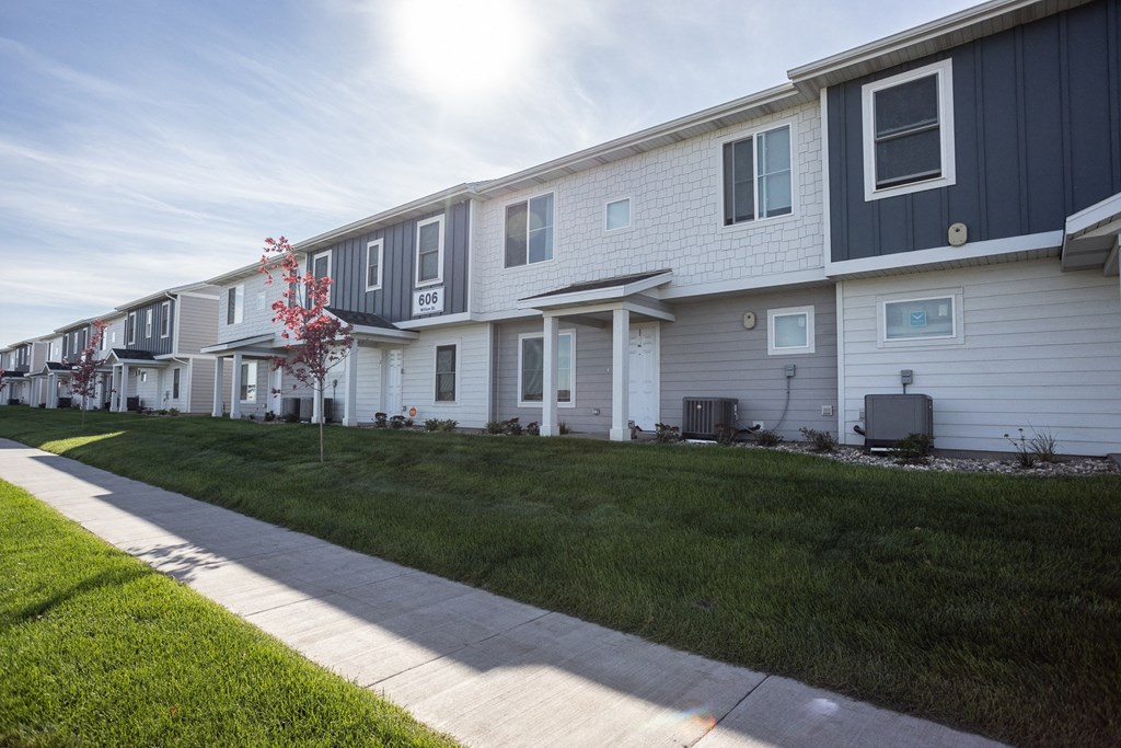 a row of houses with a sidewalk in front of them
