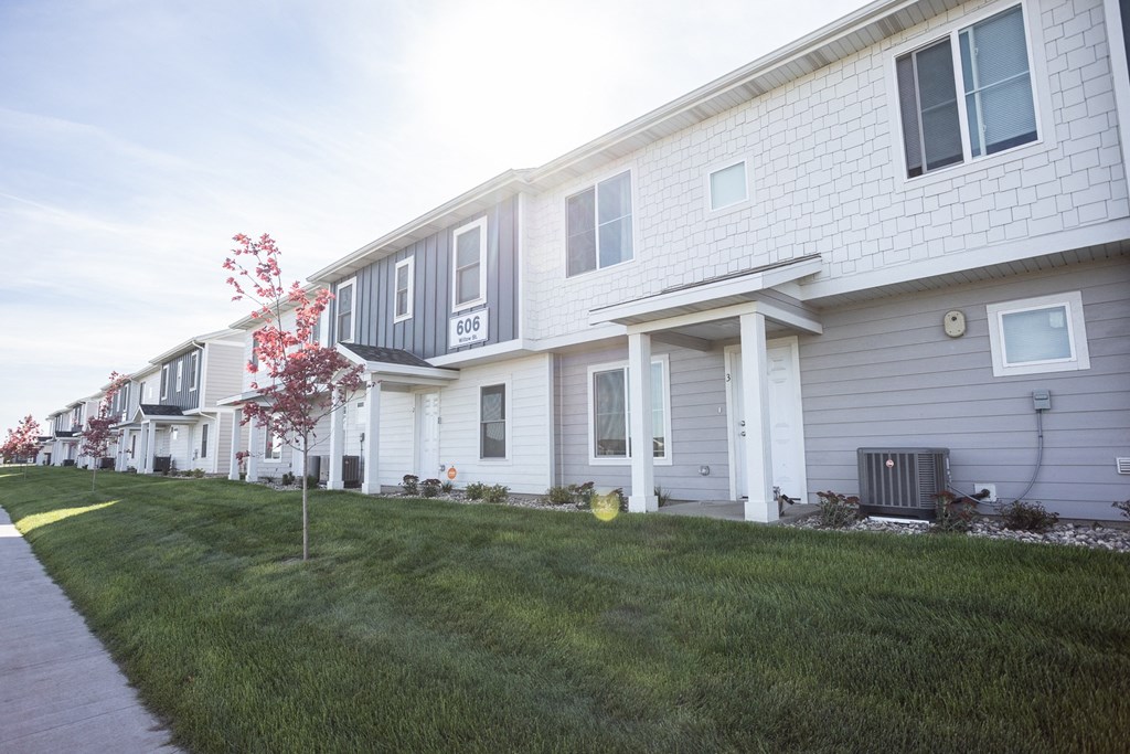 a row of houses on the side of a sidewalk
