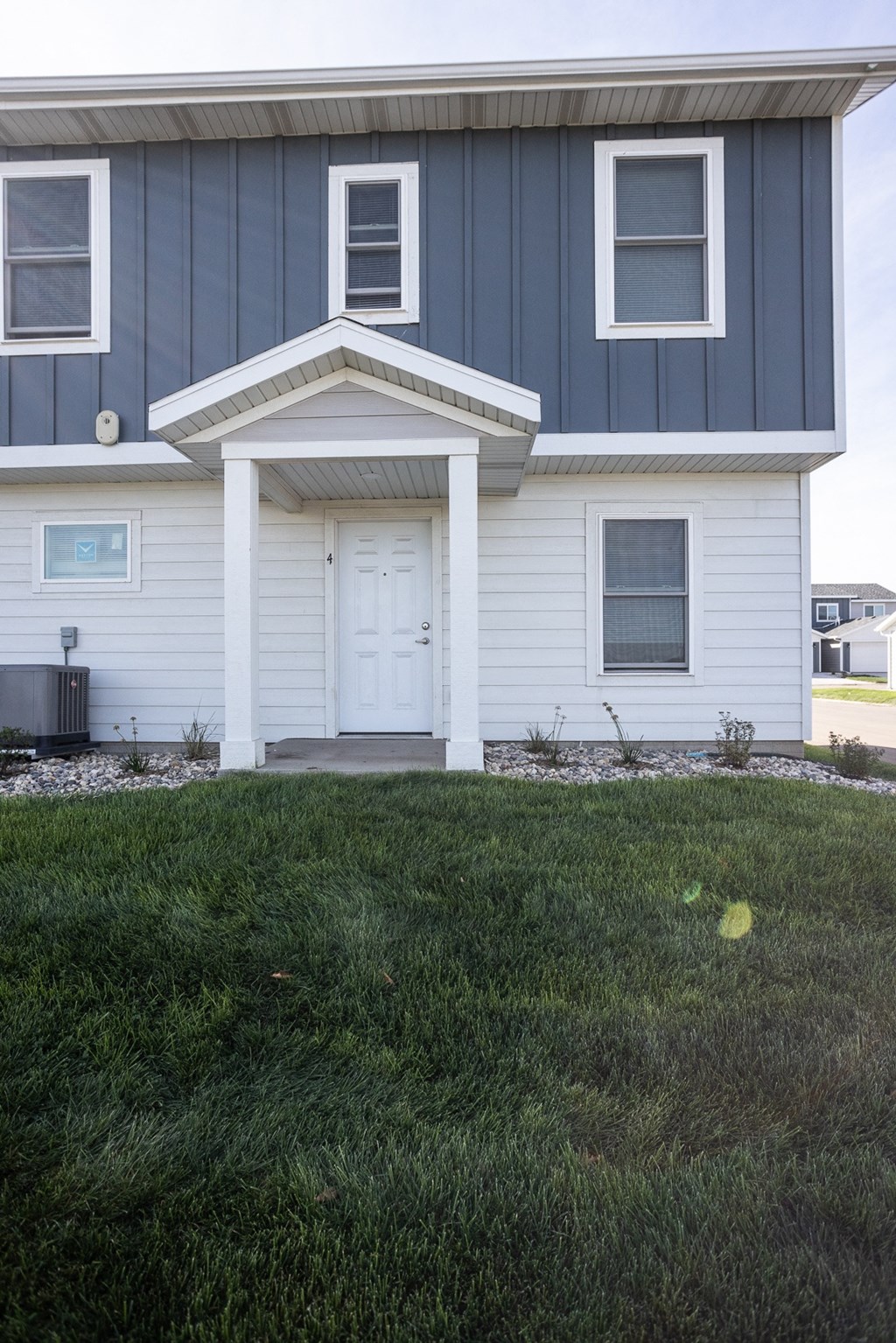 the front of a white house with a blue roof