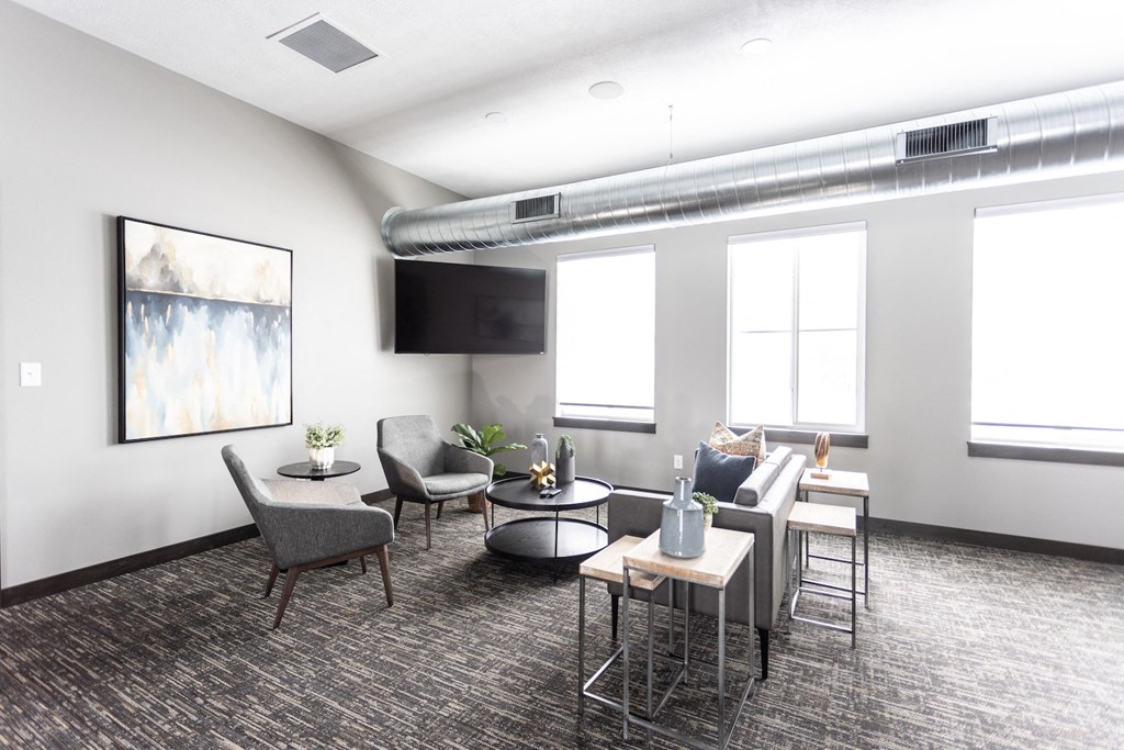 a living room with couches chairs and tables and a television