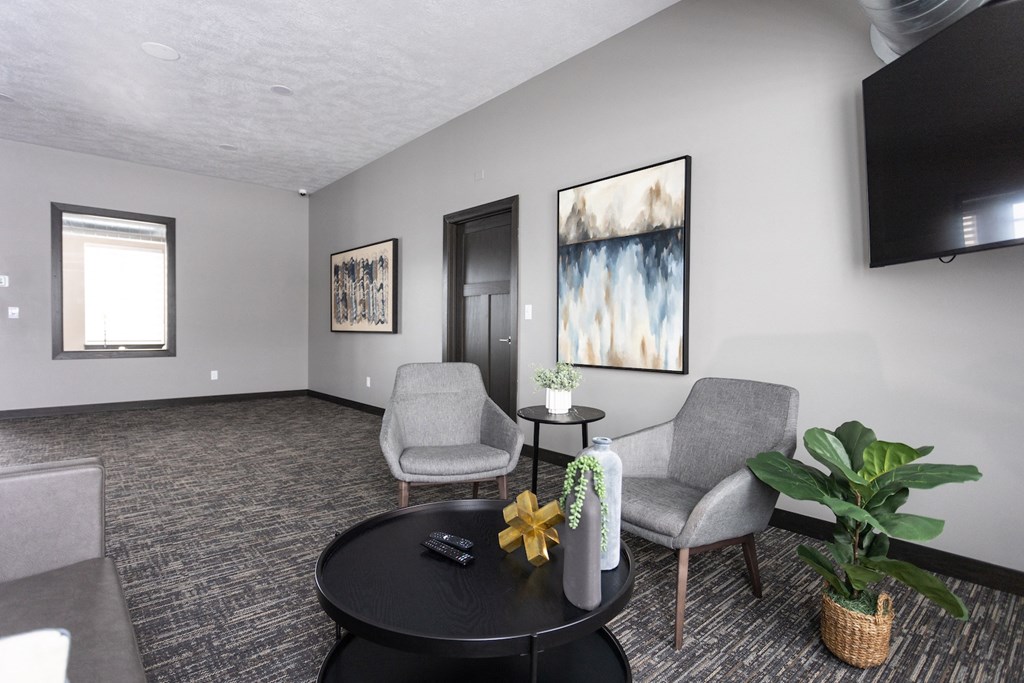 a living room with chairs and a table and a television