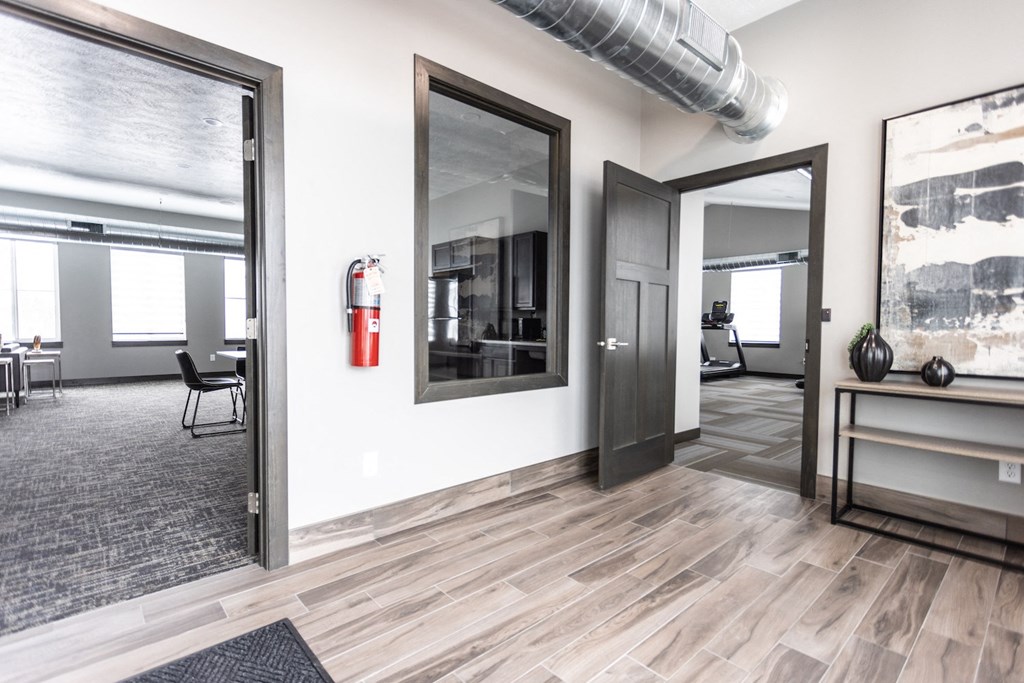 a hallway with three doors and a fire hydrant on the wall