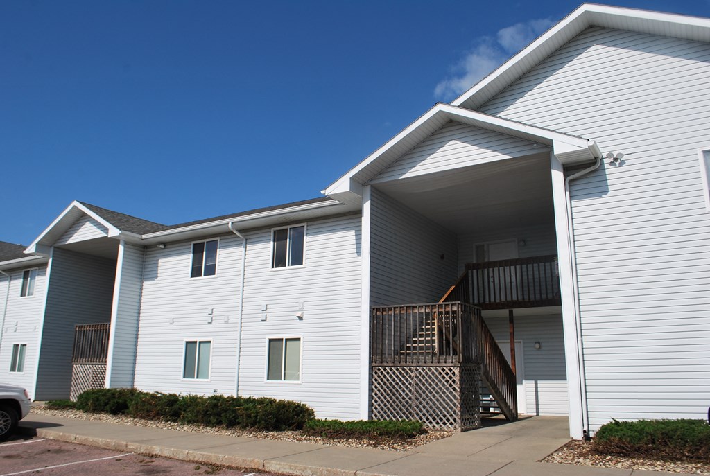 the exterior of a white building with stairs and a blue sky