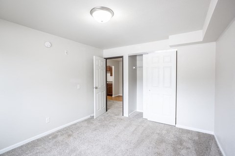 a bedroom with a closet and a door to a bathroom