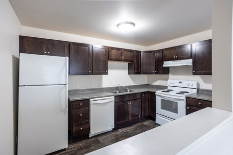 a kitchen with white appliances and dark wood cabinets