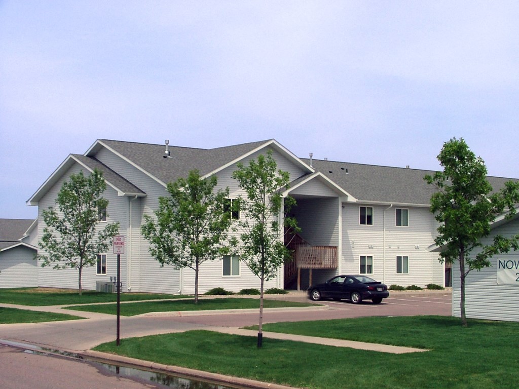 a large white building with a car parked in front of it