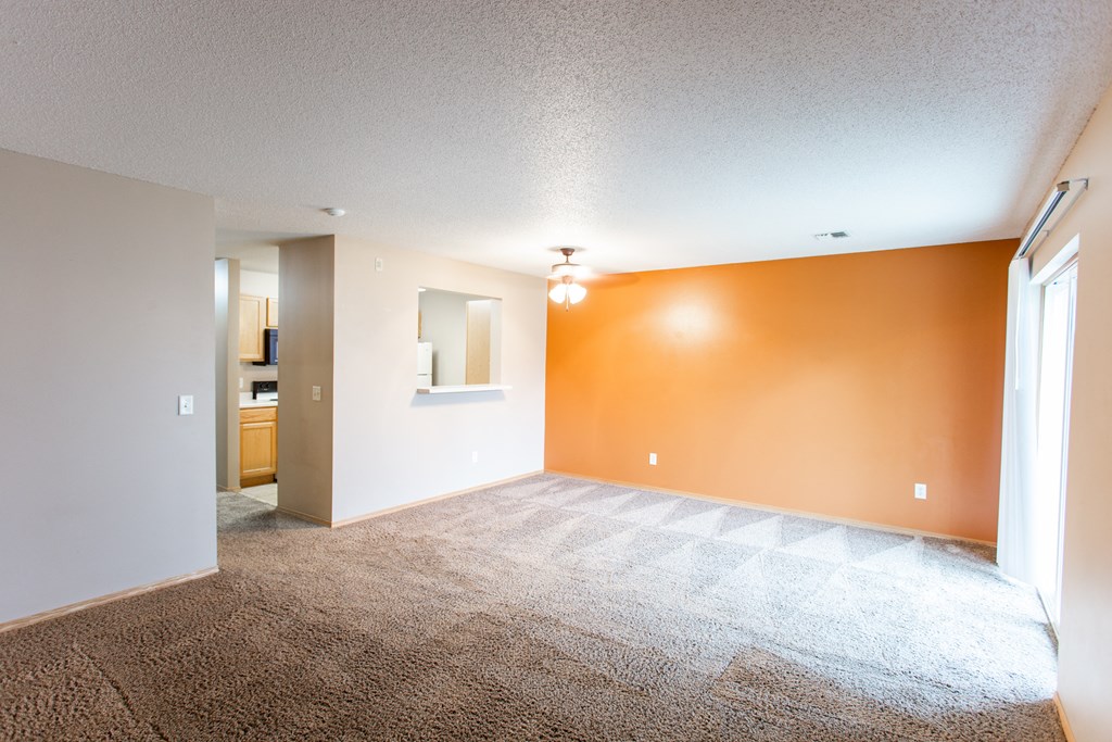 an empty living room with orange and white walls and carpet