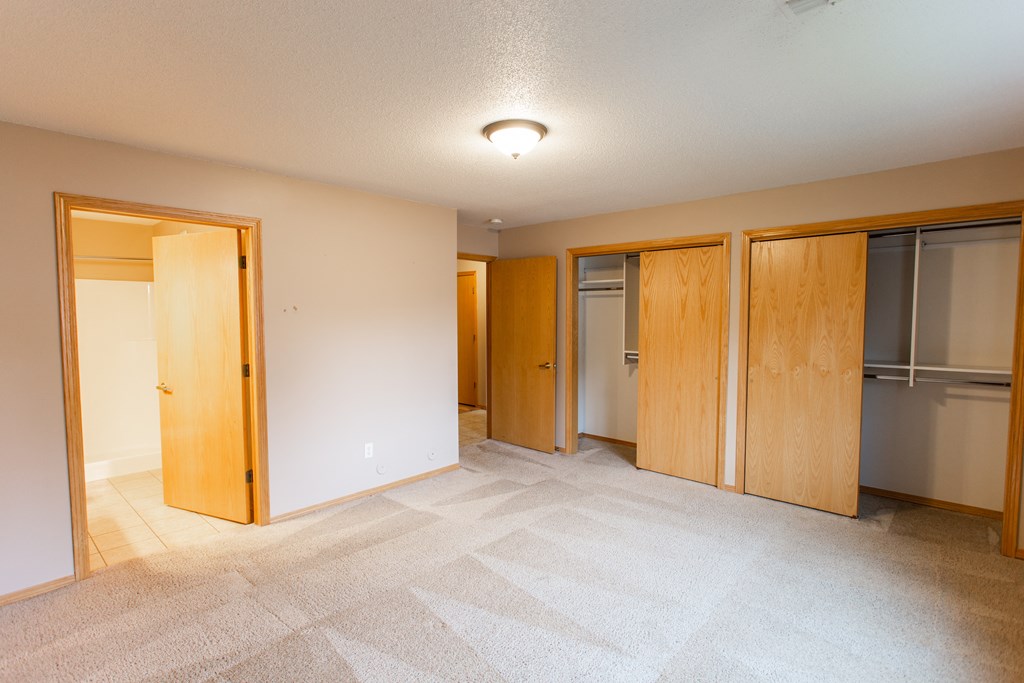 a empty room with three closets and a tiled floor
