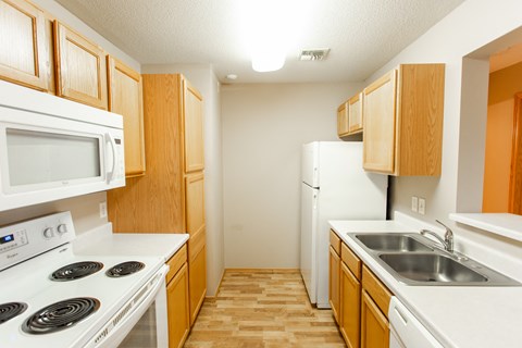 a kitchen with white appliances and wooden cabinets