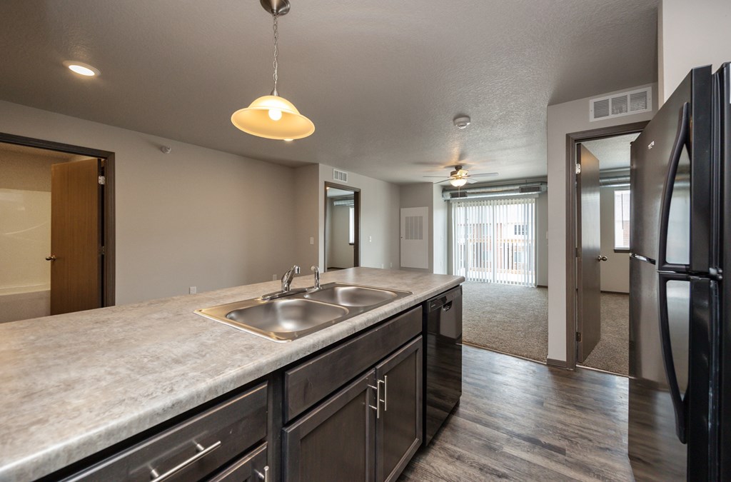 A kitchen with a sink and a refrigerator.