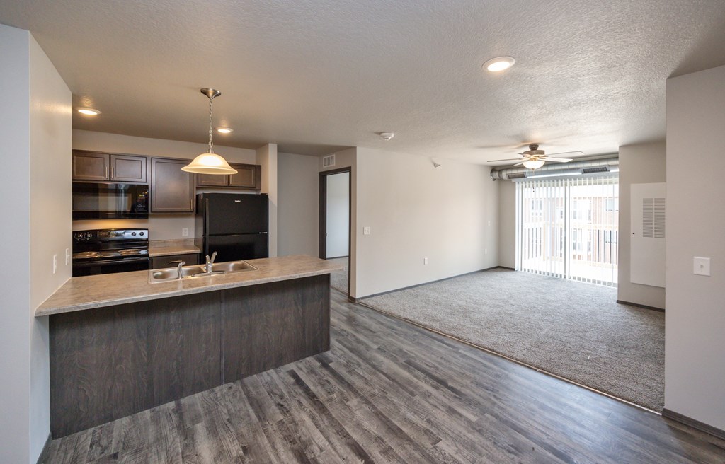 A modern kitchen with a bar area and a large open living space.