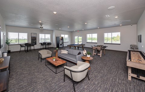 A spacious living room with grey carpeting and furniture.