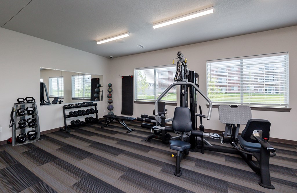 A well-equipped gym with a variety of exercise machines and weights.