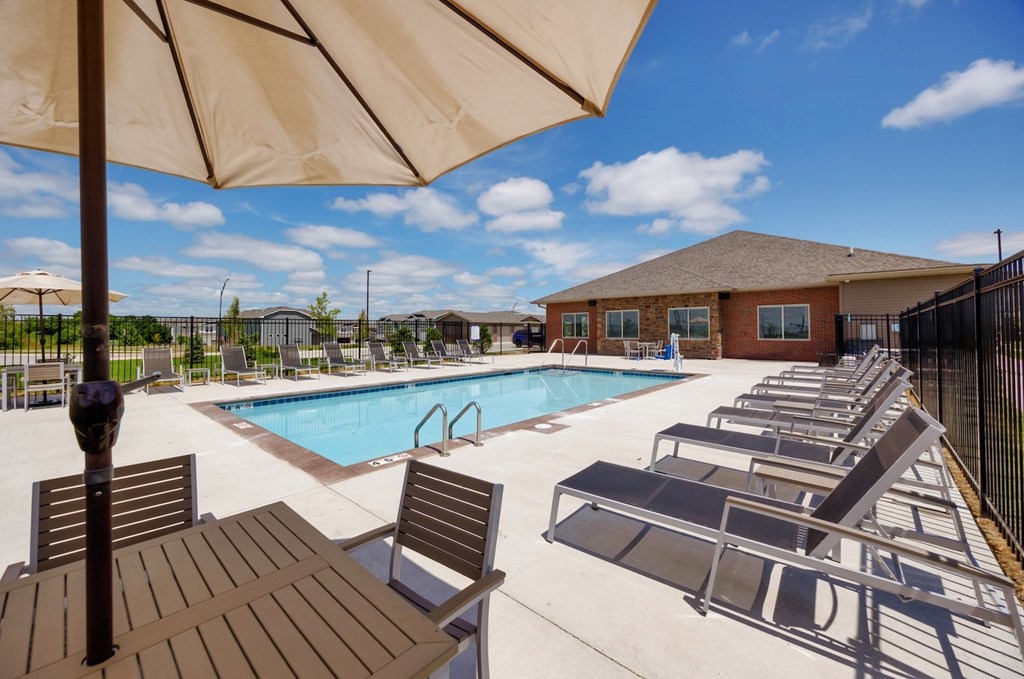 A pool area with sun loungers and a table.