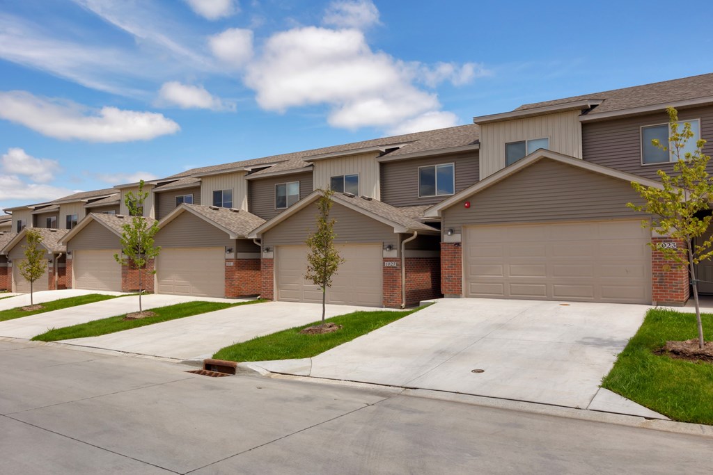 A row of houses with garages and driveways.