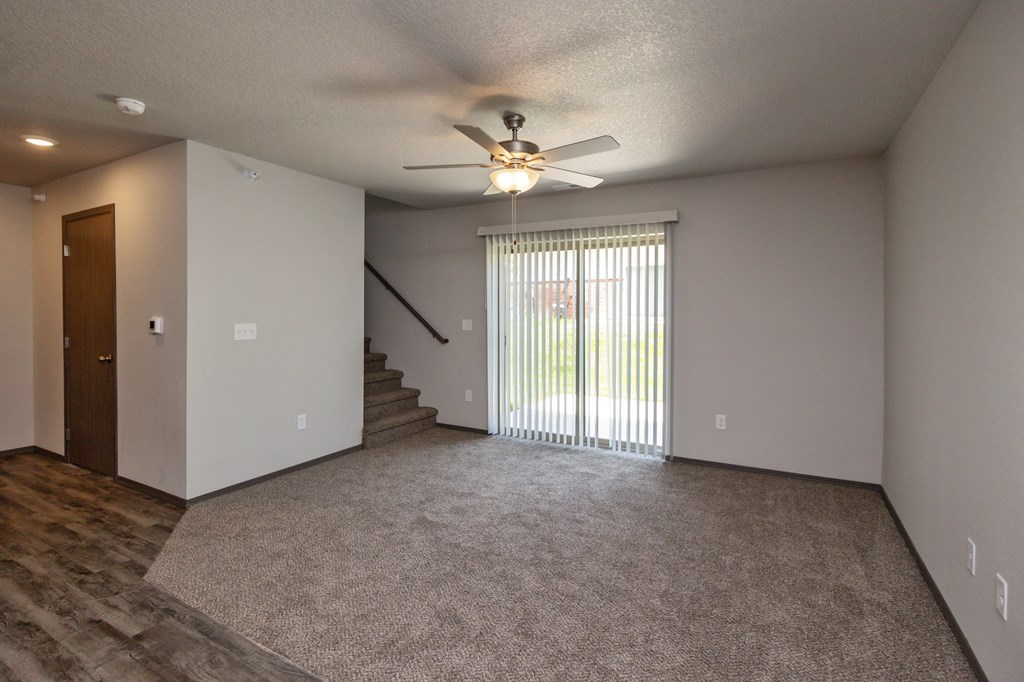 A room with a ceiling fan and a carpeted floor.