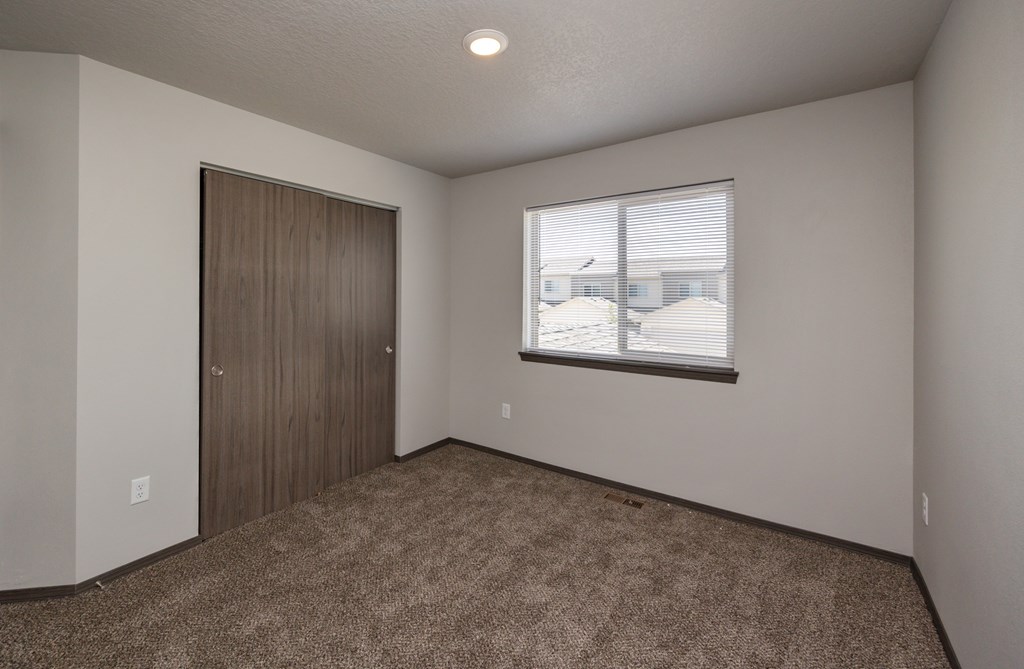 A room with a brown carpet and a brown door.