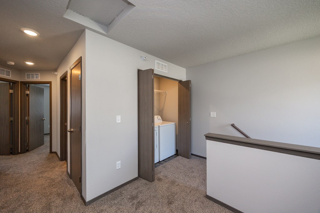 A room with a white wall and a brown carpet.