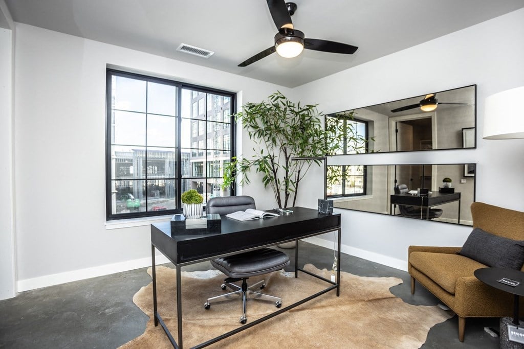 an office with a large window and a desk with a chair