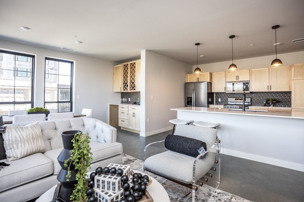 a living room and kitchen with couches and a table
