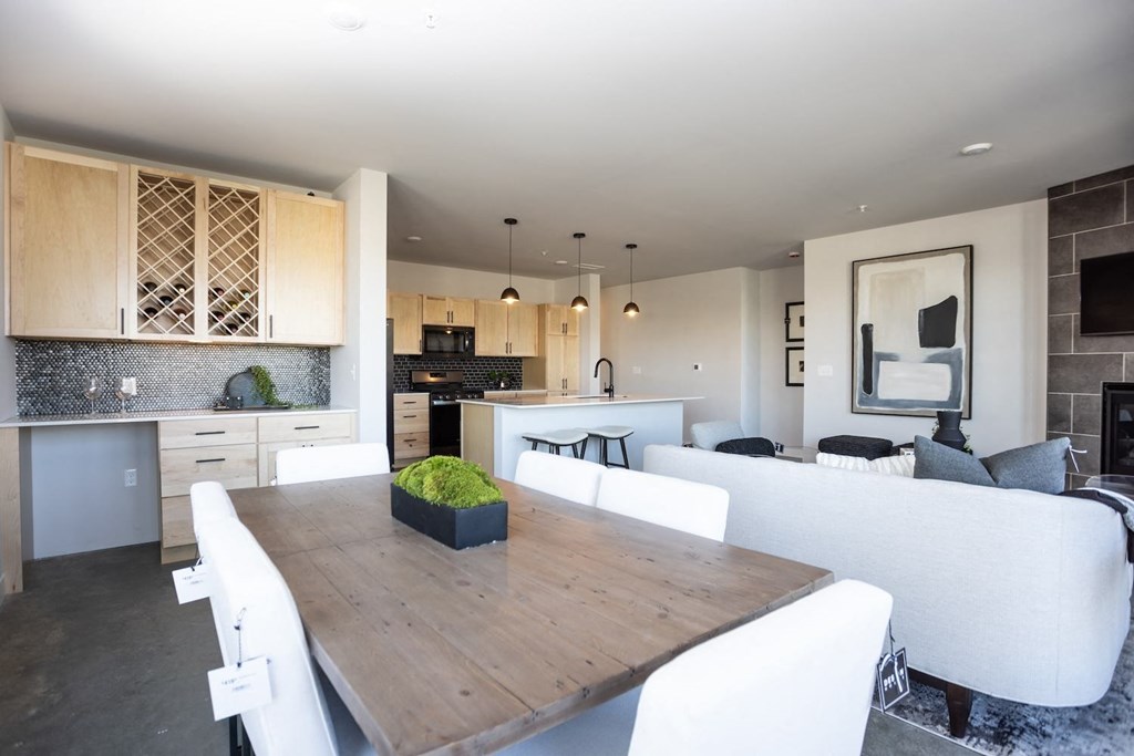 a kitchen and dining room with white chairs and a table