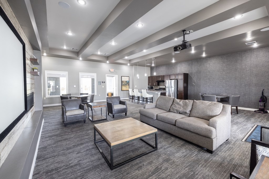A modern living room with grey carpeting and furniture.