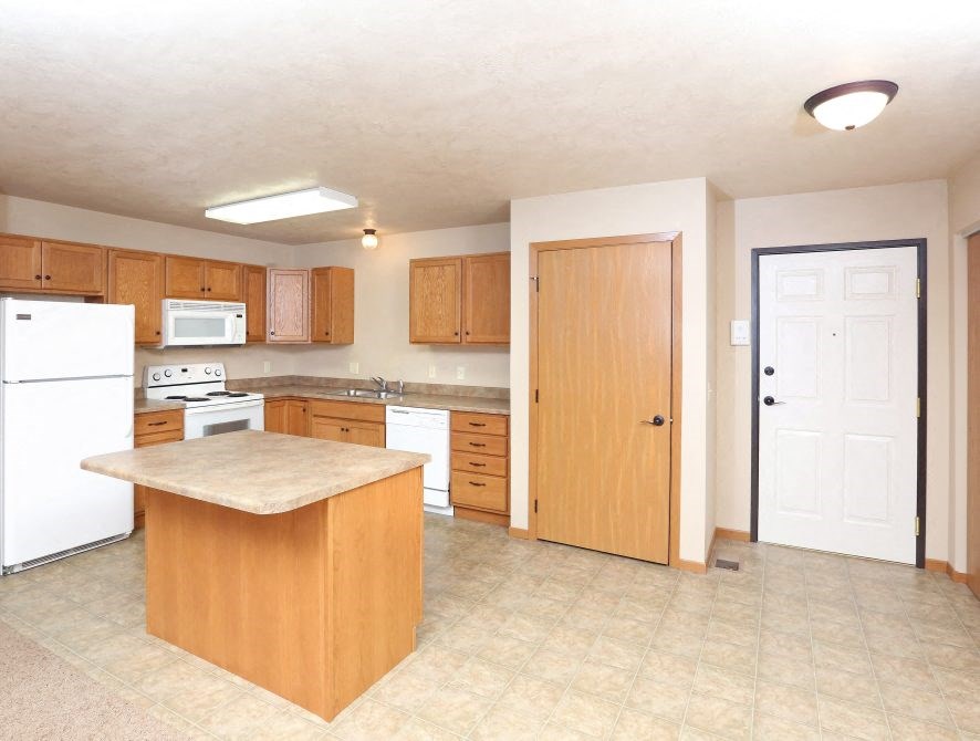 a kitchen with an island and a white refrigerator