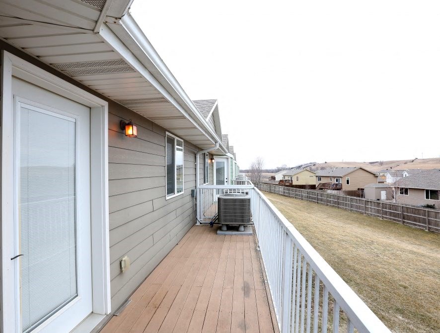 the spacious balcony has a view of the yard and the house