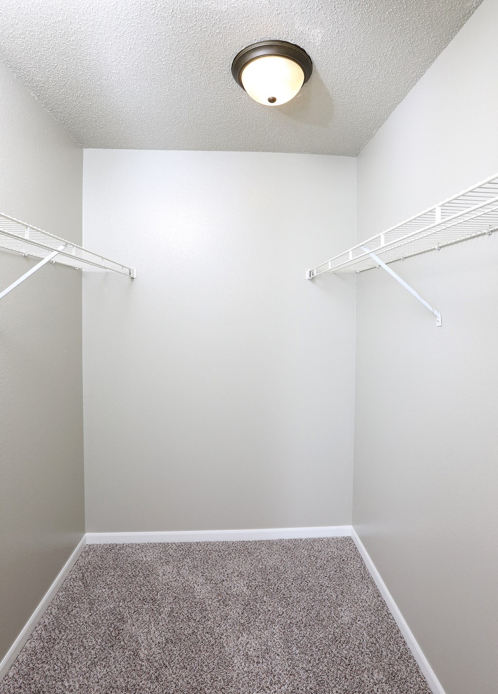 an empty room with white walls and a ceiling light