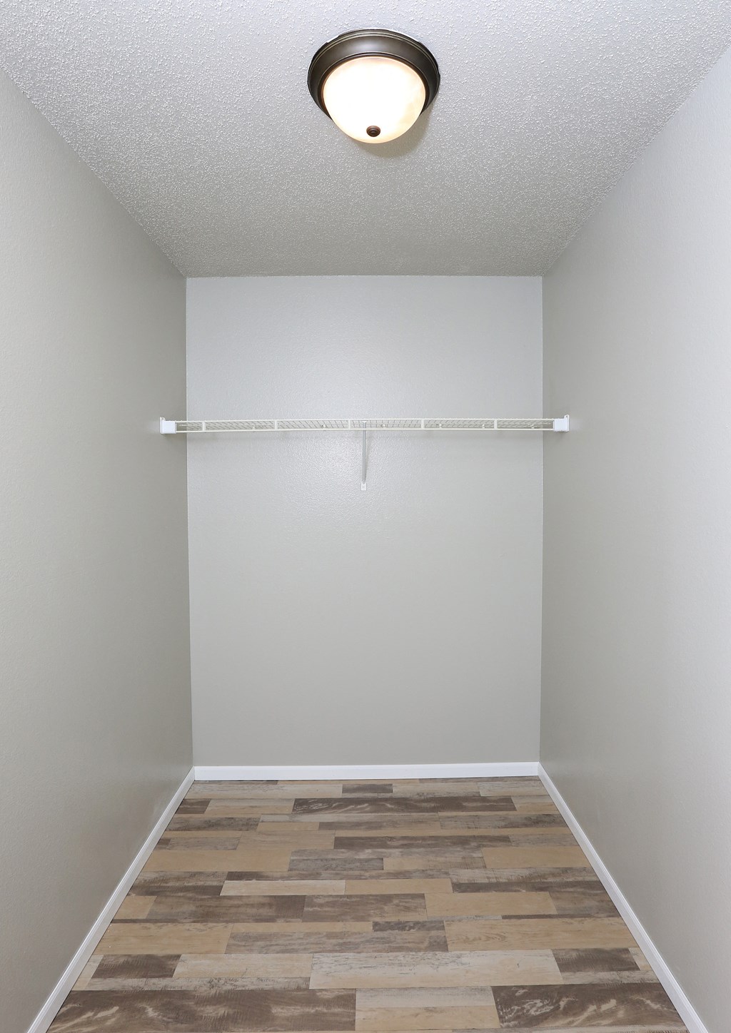 an empty room with a wood floor and a light on the ceiling