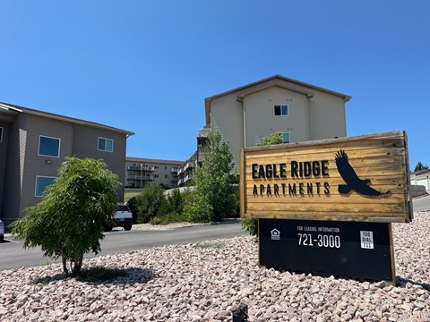 A sign for Eagle Ridge Apartments is in front of a building.