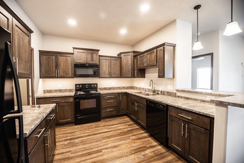 A kitchen with dark wood cabinets and a white fridge.