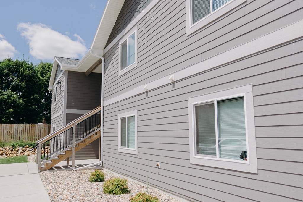 the side of a house with a staircase and a window