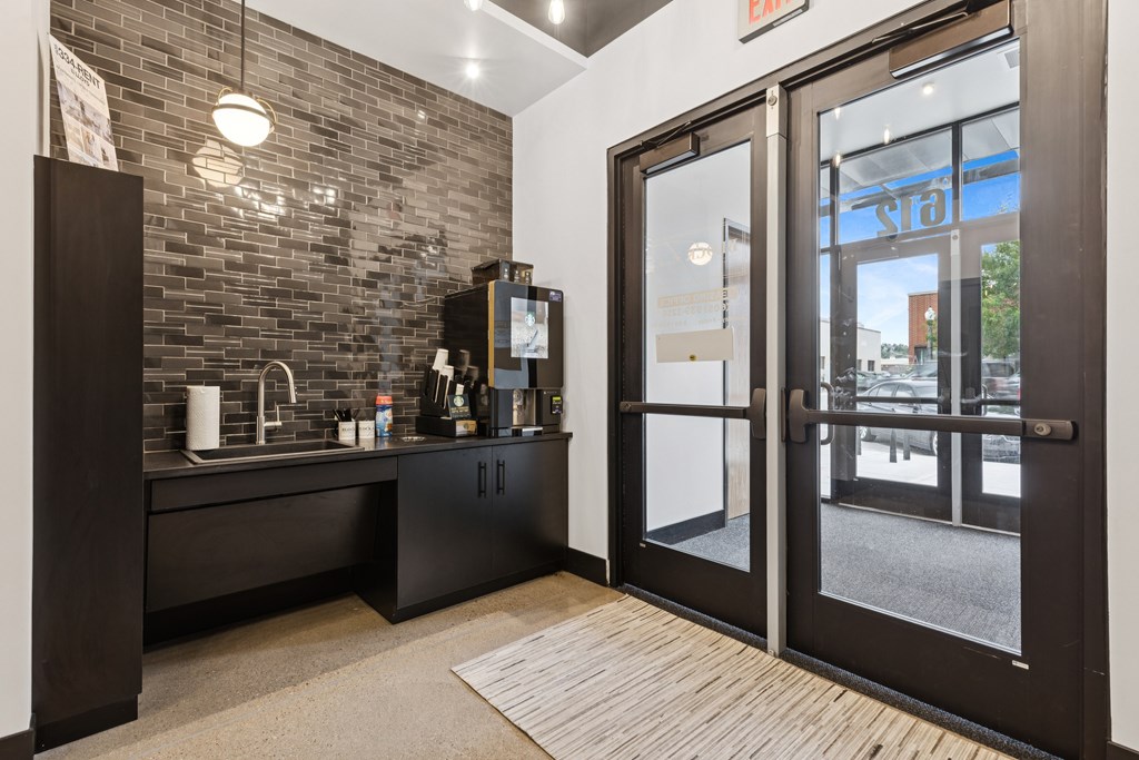 A black and white kitchen with a glass door entrance.