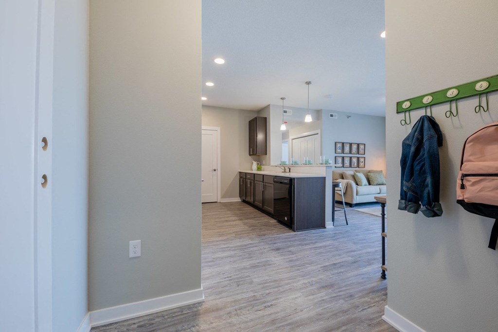 an open living room and kitchen with a hallway to a bedroom and a living room