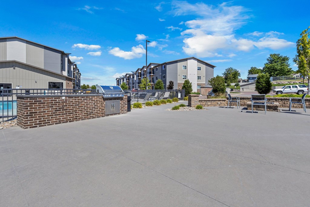 A parking lot with a building and a wall in the background.