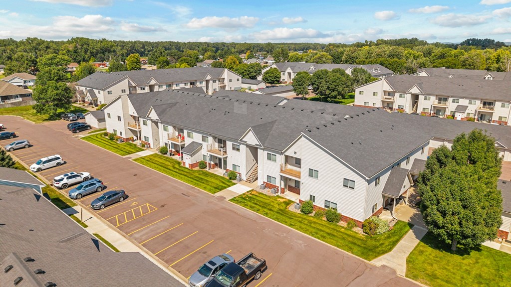A large white building with a parking lot in front.