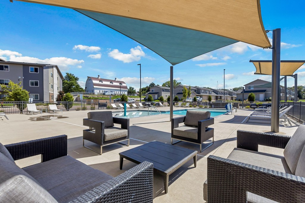 A sunny day at the poolside with lounge chairs and umbrellas.