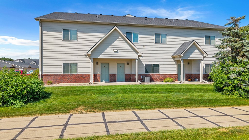 A two-story house with a front yard and a driveway.