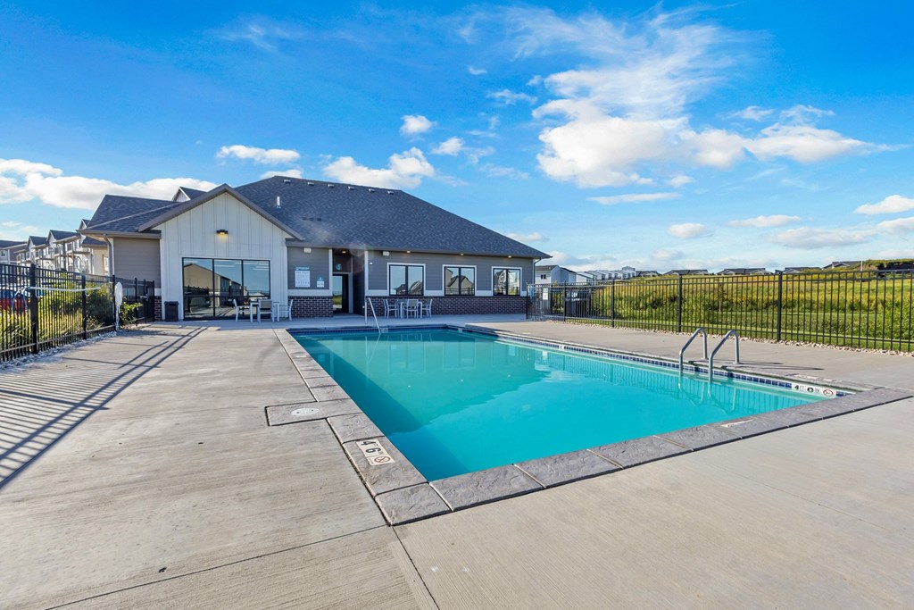 A swimming pool in front of a house.
