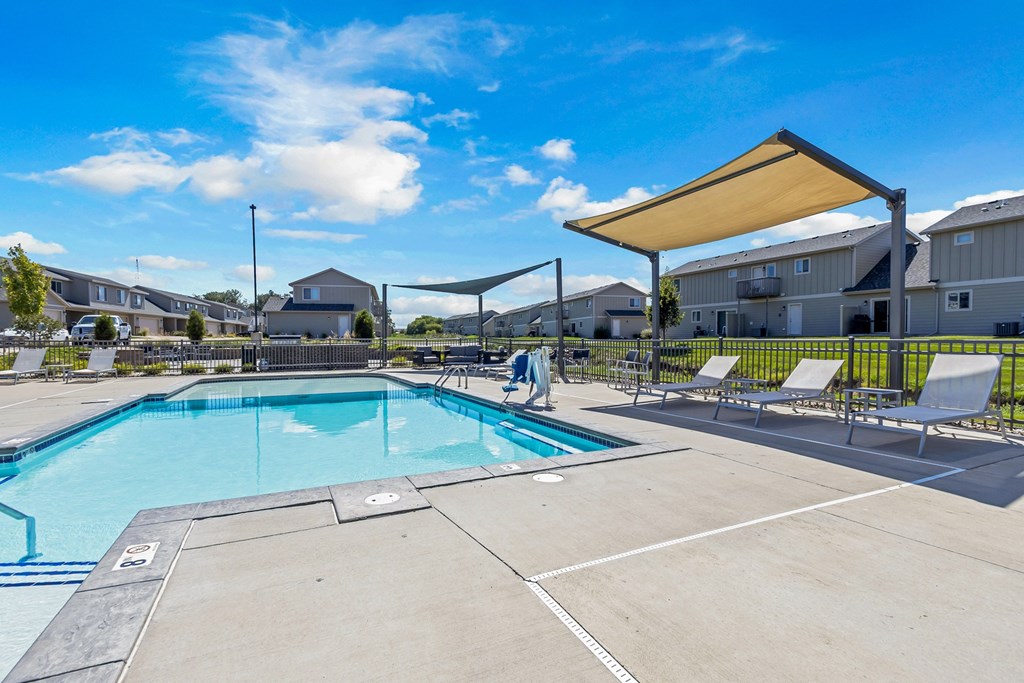 A large outdoor swimming pool with a sunshade.
