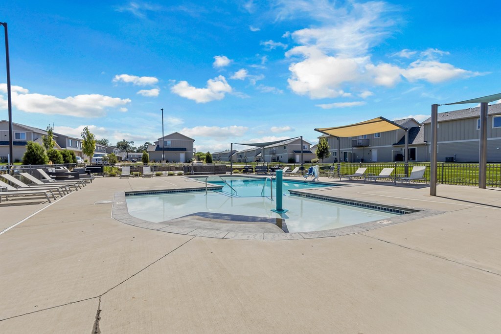 A swimming pool in a residential area with houses in the background.