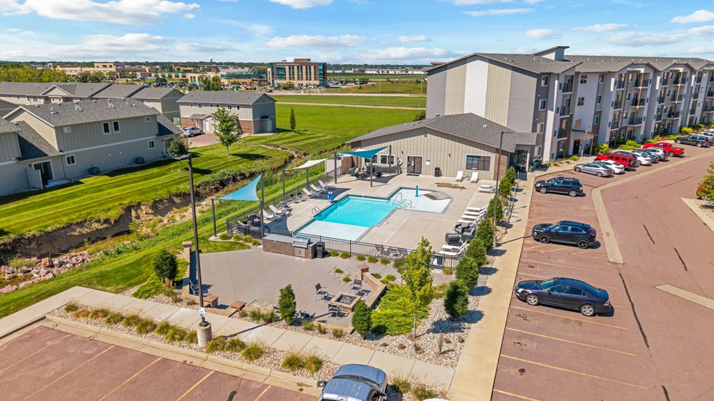 A large building complex with a pool and parking lot.