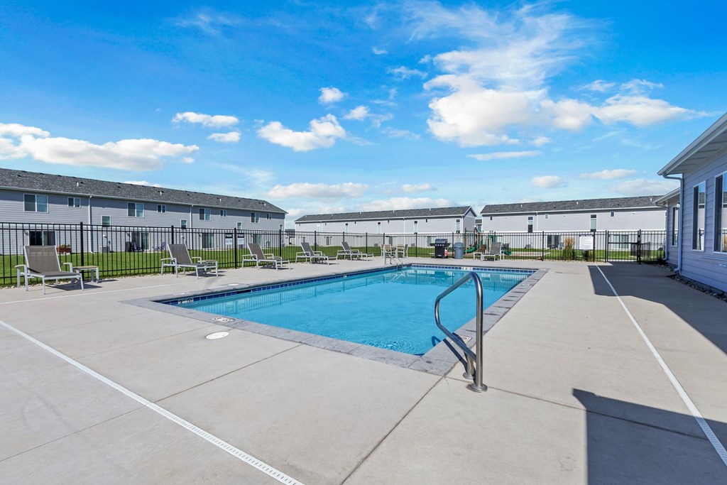 A swimming pool in a sunny outdoor setting.