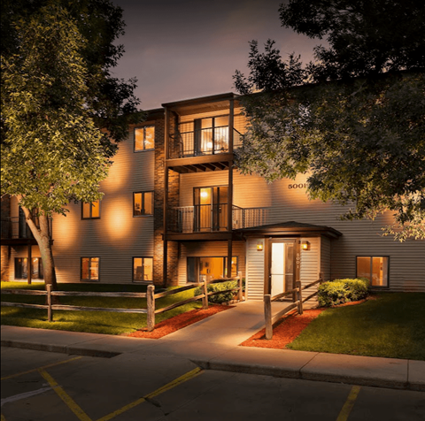a city at night with lights on the side of a building
