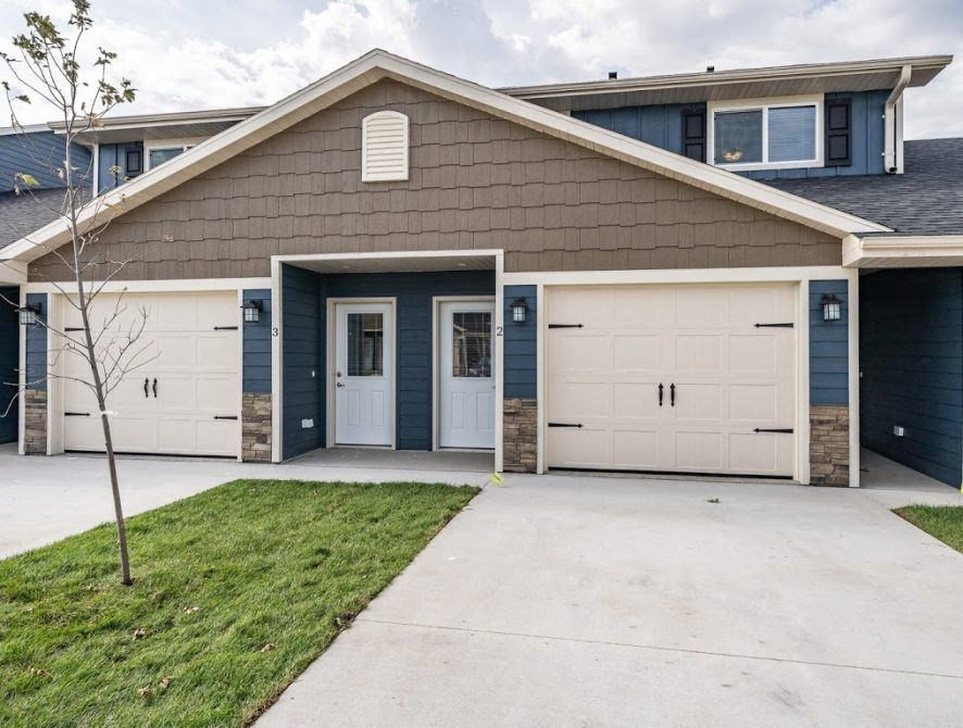 a house with white garage doors and a driveway